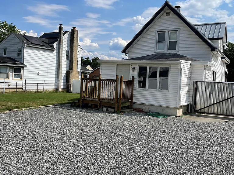 Private rear parking area with gravel surface, plus additional driveway parking for extra convenience.