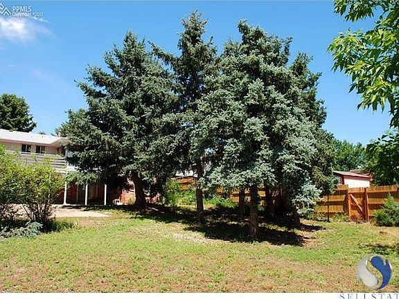 View of the large back yard and mature landscaping with new fence on the side