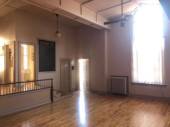 View from outside first floor bedroom, looking across living room, seeing into the pantry and at open entrance door