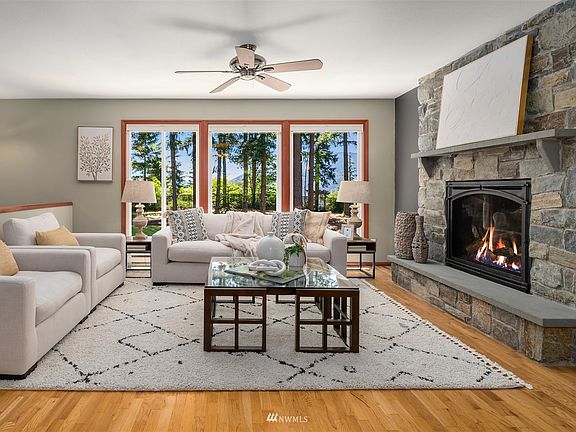 Impressive living room features a floor-to-ceiling stone fireplace with mantle and hearth.>