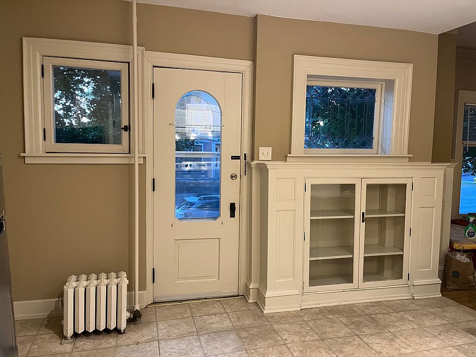This apartment has a private entrance.
On the right is a built in china cabinet and a leaded glass window,