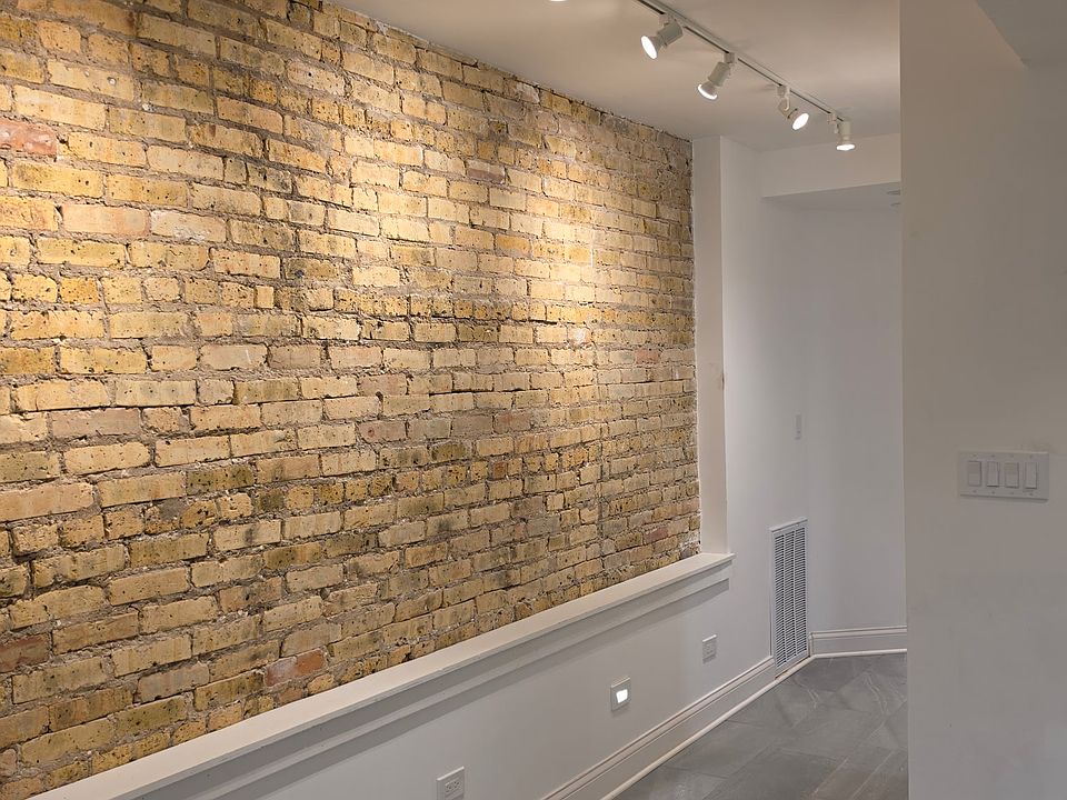 Loft like exposed brick walls with adjustable track lighting for your art work