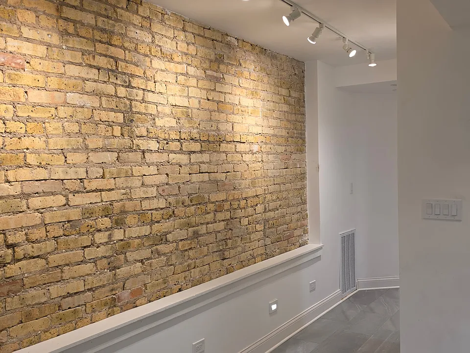 Loft like exposed brick walls with adjustable track lighting for your art work