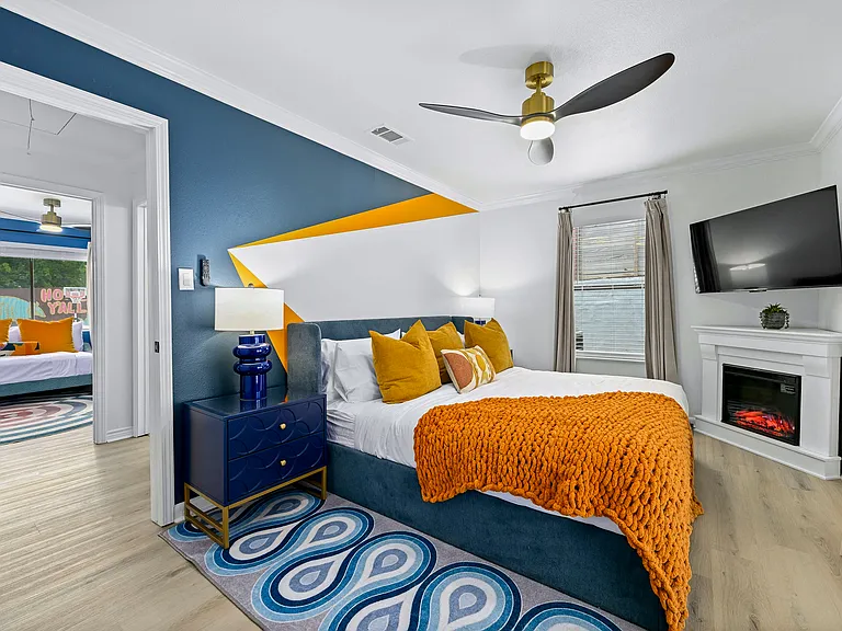 Custom mural and luxe linens in the King Suite. Cozy up to that fireplace and watch your fav shows!