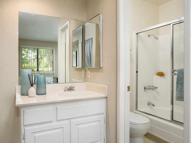 Classic bath with white countertops and white cabinetry