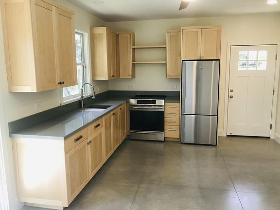 New kitchen/dining/living space with stone floors and counters