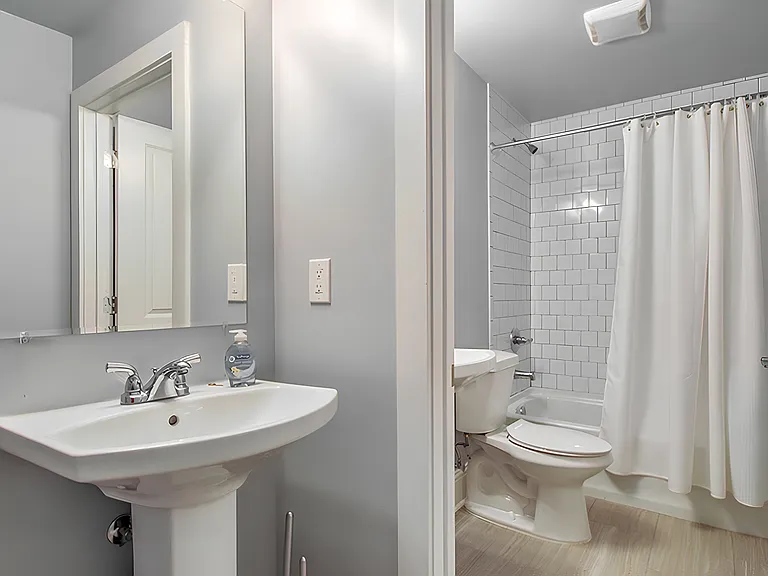 Brand new bathroom with tile floor and walls. There is a second sink outside the bathroom.