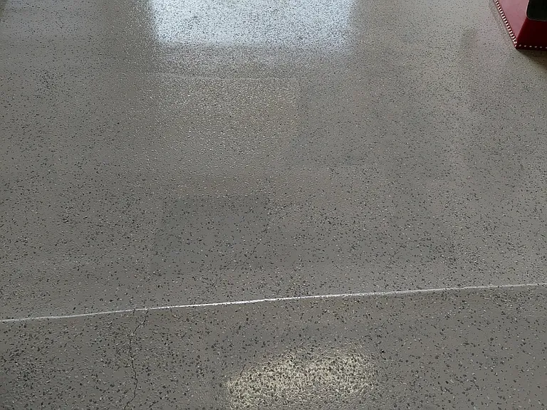 A single car garage with a new style in door/out door epoxy floor with multi-grey specks