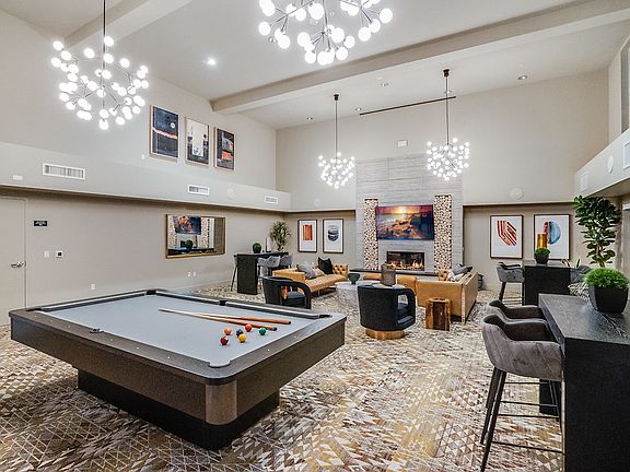 Clubhouse with fireplace, pool table, couches, and chairs.