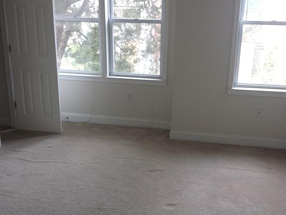 Main bedroom in front of house. Bright, with three windows and two good-size closets.