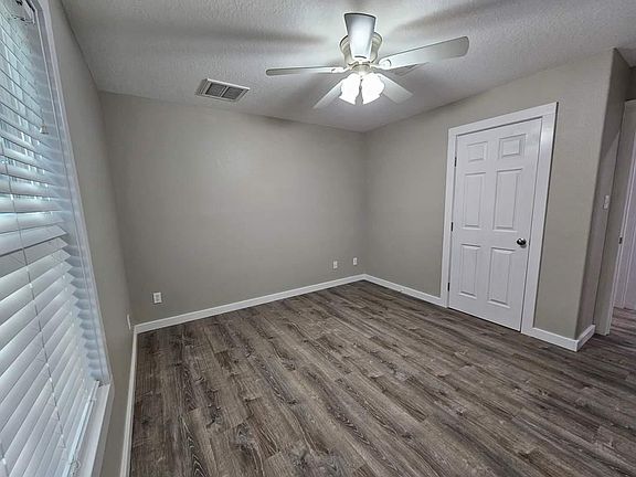 Master bedroom with 2" blinds and ceiling fan.