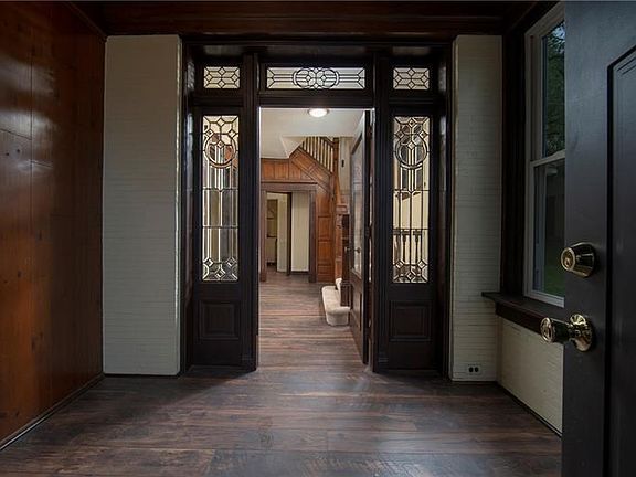 ENTRYWAY-Features high grade laminated floors, neutral tones, polished dark wood and leaded French doors.