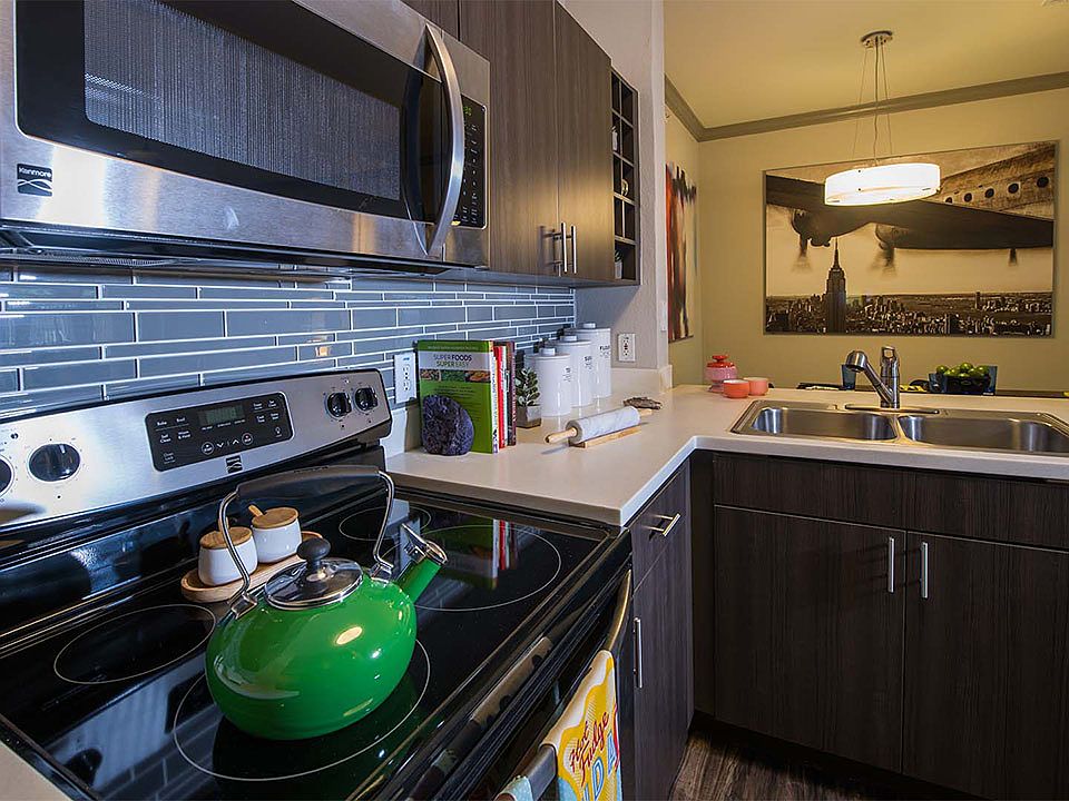 Apartment Kitchen with Stainless Steel Appliances, quartz counters and wood floors.