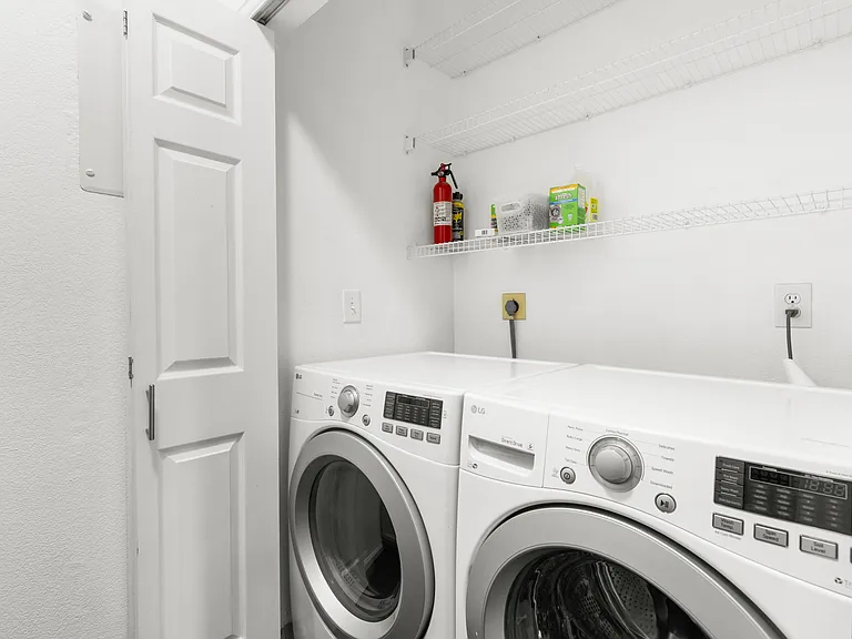 In-unit washer and dryer with additional shelving for storage and organization.