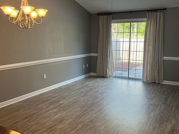 Living room & Dining Room area with two sky lights and sliding glass doors that lead to the outdoor patio area. LVP floors installed summer of 2023.