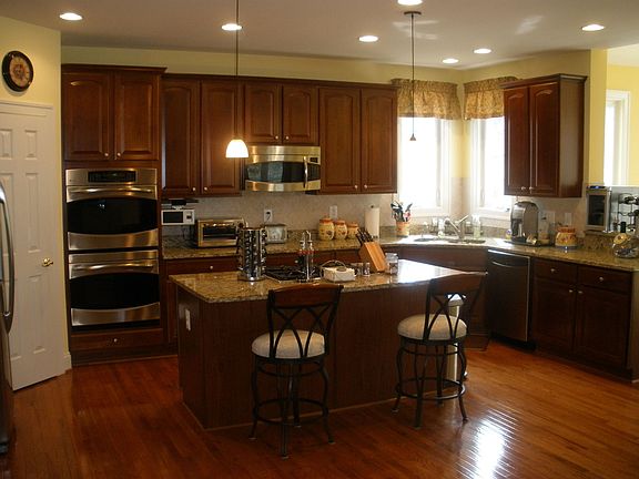 kitchen with stainless appliances, island, hardwood, backsplash, etc. 