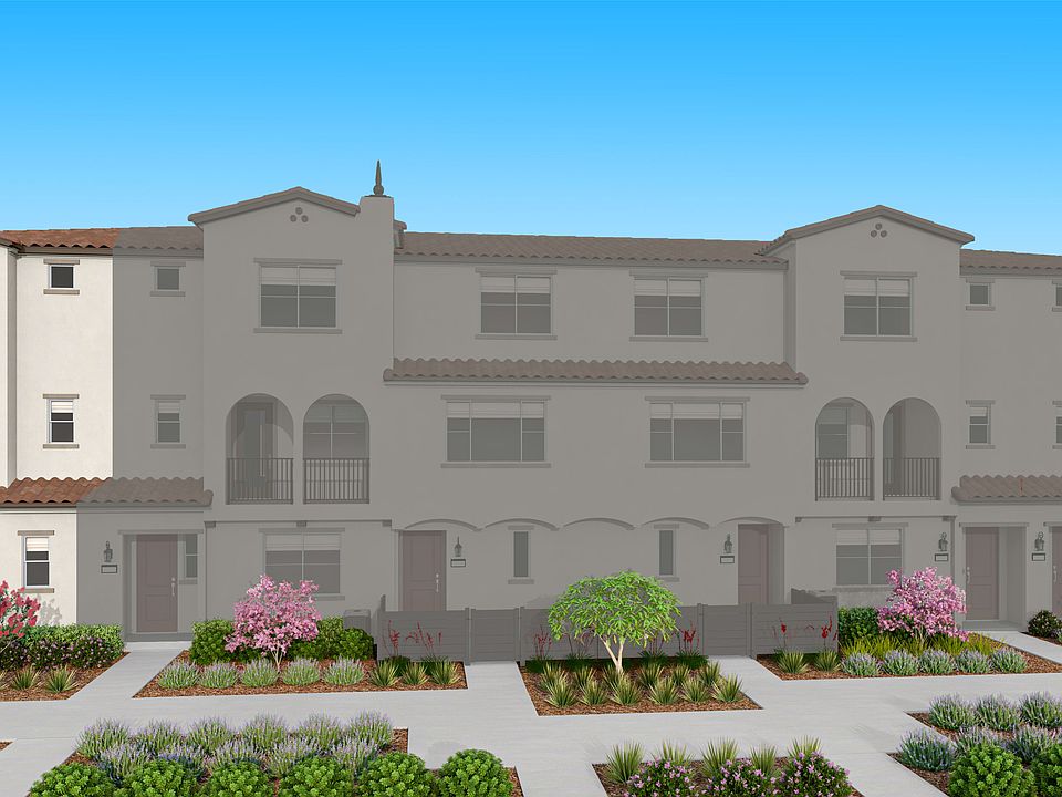 A multi-story, Mediterranean-style residential building with arched windows and a tiled roof, surrou