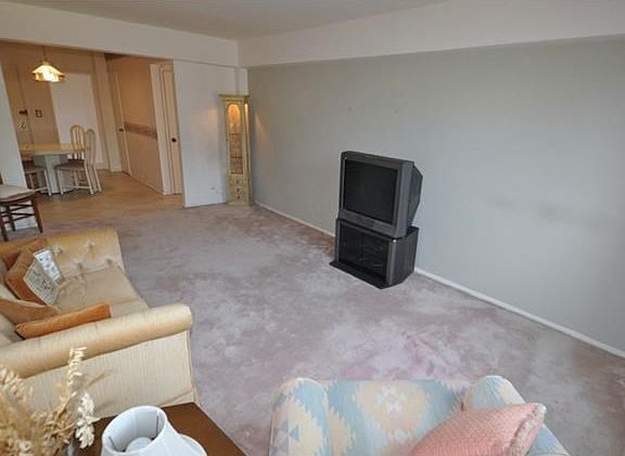 Large living room with covered hardwood floors.