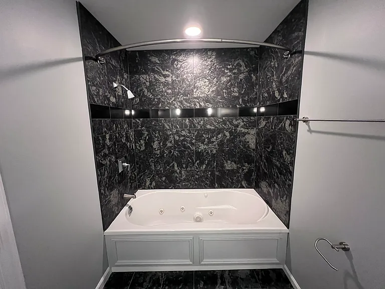 Lower level bedroom attached bathroom. Tub has Jacuzzi jets.