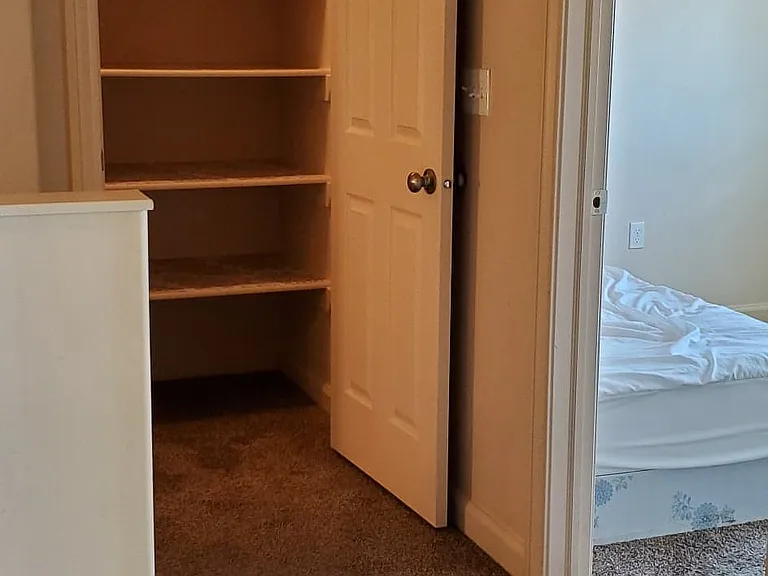 spacious shelved closet with light, top of stairs