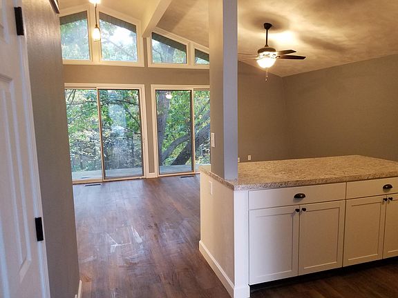 Kitchen, living, and dining with sliding door to upper level