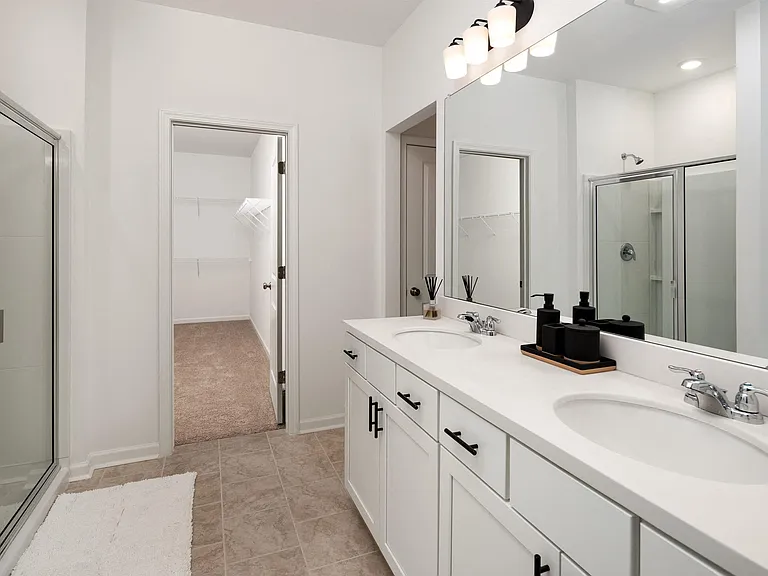Primary bathroom with double vanity, walk-in shower and walk-in closet.
