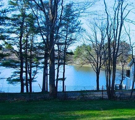 View of Spruce Creek from house deck, front yard, early spring