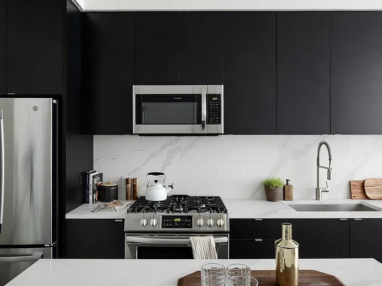 Dark wood, frameless cabinetry with white quartz countertops