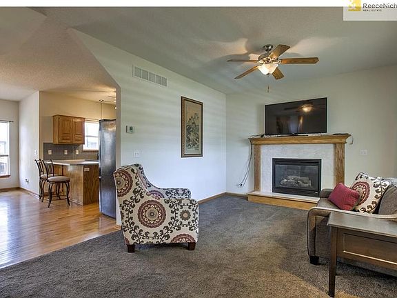 Living room at front entry with ceiling fan and gas fireplace