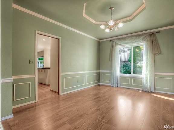Spacious formal dining room with a coffered ceiling, chair rail & wainscoting.
