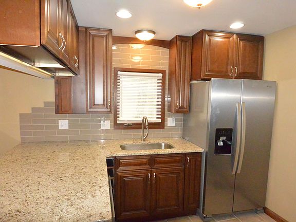 Full sized fridge, huge granite slab under cabinet lights, plenty of can lights and stainless fixtures.