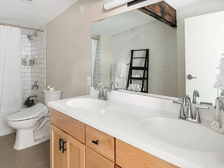 Second floor full bathroom with double sinks and a tub