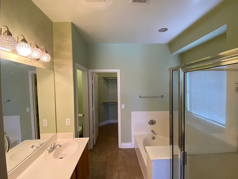 Master Bathroom. Dual sinks, separate toilet with door for privacy, shower, and large tub.