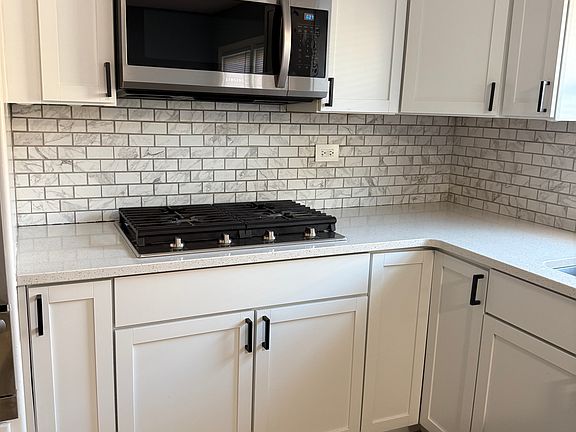 Stainless steel appliances and quartz countertops.