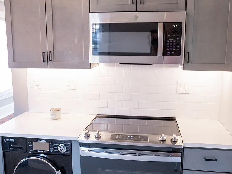 Kitchen with stove, microwave and washer/dryer unit