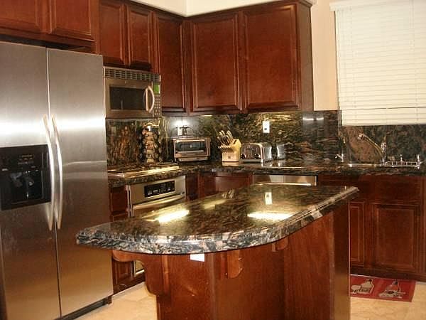 Beautiful kitchen with cherry wood cabinets and rare tigre granite