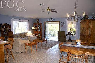 Large open family room with dining area and high cathedral ceilings and ceramic tile throughout.