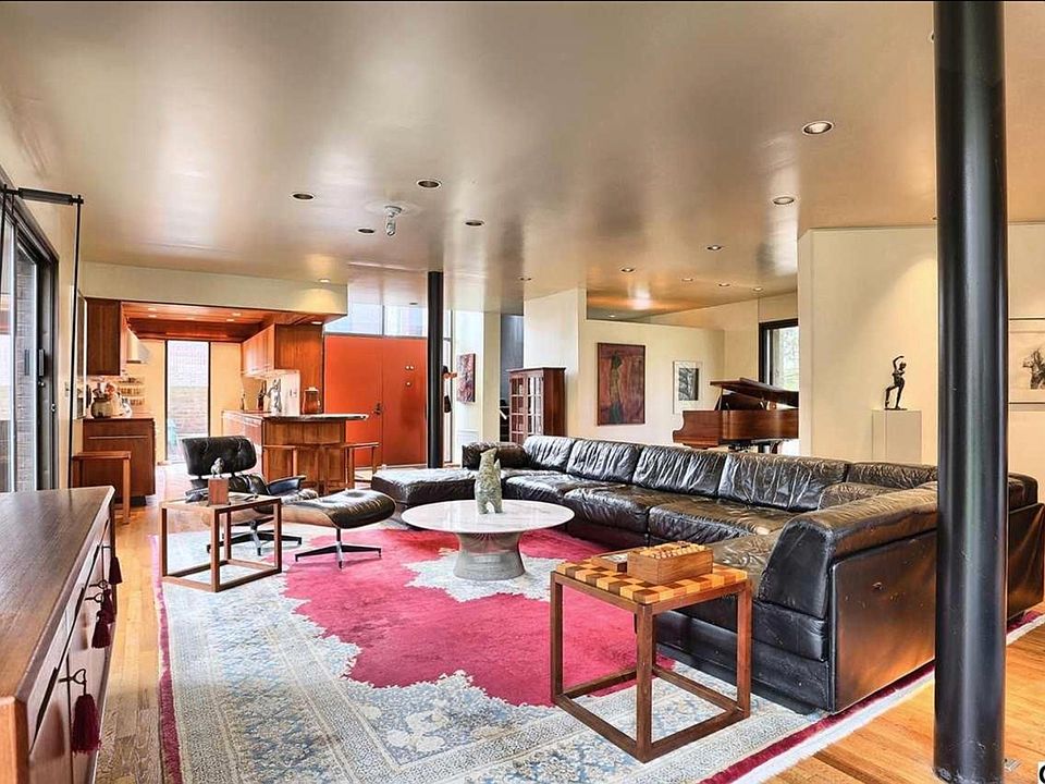 Large open living space with hard wood floors and floor to c