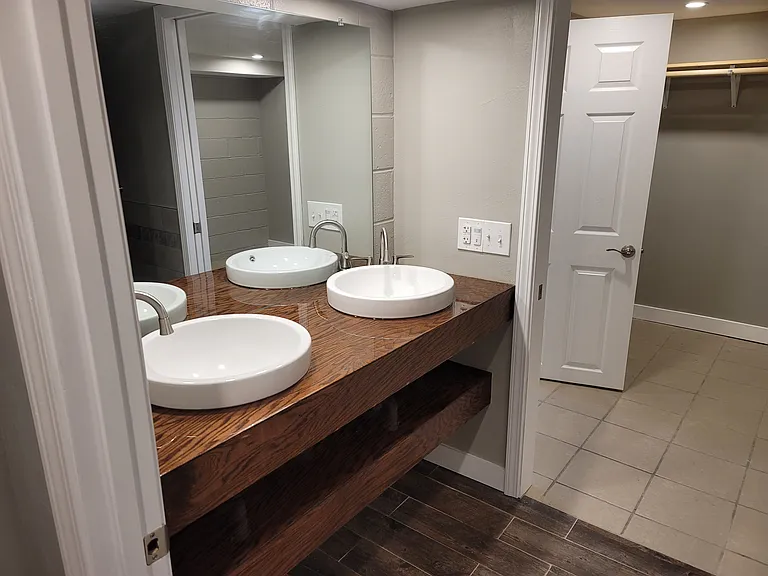 Main bathroom -- double vanity sinks, large mirror, open shelving