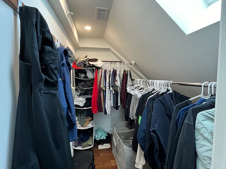 Master suite closet with lots of clothes! You could also put a small desk or a printer cabinet in here.