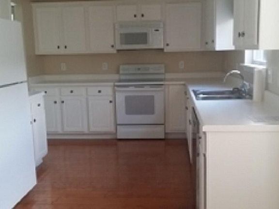 Kitchen with all white appliances furnished.