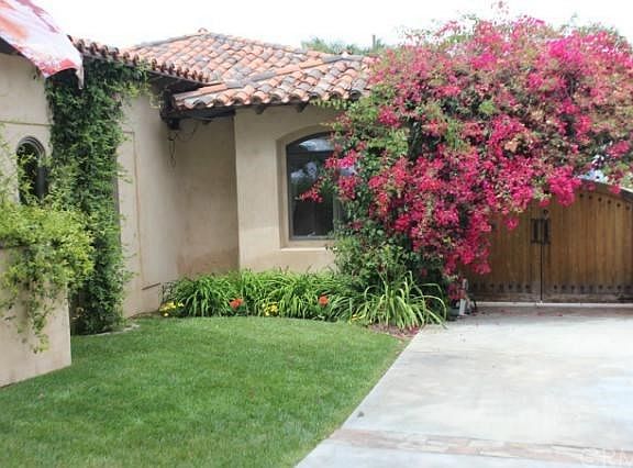 Beautiful entry to side yard and grass covered driveway to rear 2 car garage