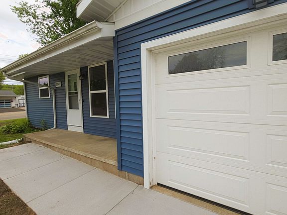 View of new Siding and Garage Door and Front Porch. New concrete driveway and walkway.
