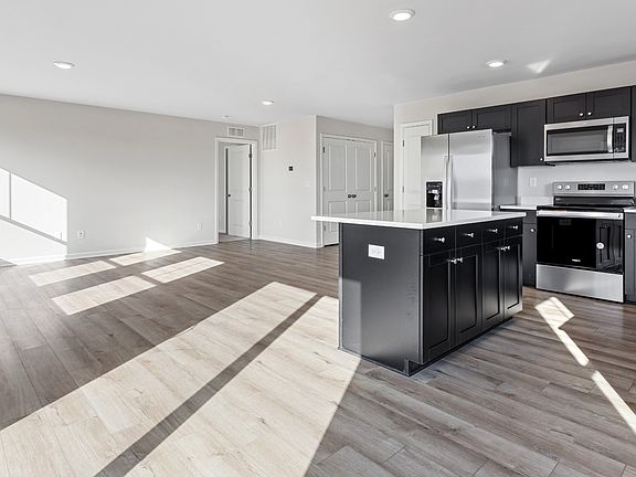 Open main floor kitchen and family room in a DRB Homes Cranberry plan at the Village of College Park