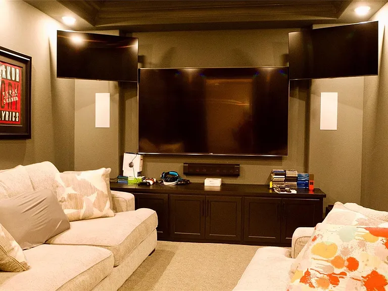 Dedicated media room featuring tray ceiling, recessed lighting, and wall-mounted speakers