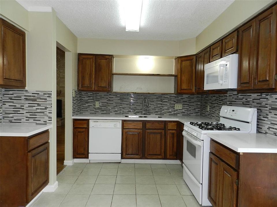 Updated kitchen features tile backsplash, quartz counters, and gas cooking.