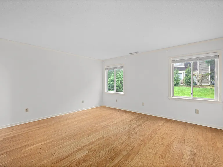 Main level primary bedroom with en suite, large closet, hardwood floors, and privacy