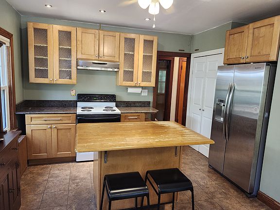 Large kitchen island, lots of cabinet space and pantry next to fridge