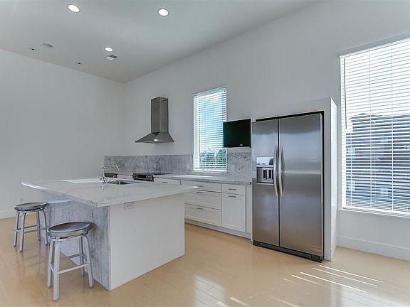 Beautiful, open kitchen with SS appliances, easily maintained DuPont Zodiac Quartz counters, and Carrara marble backsplash.