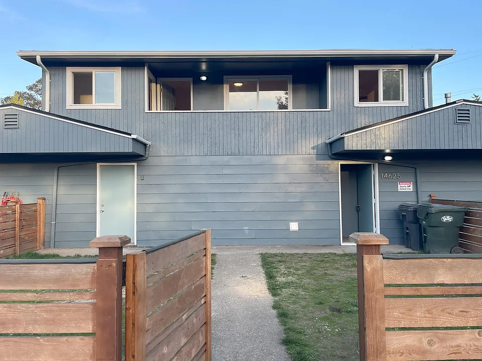 Front of triplex. Entrance to fenced yard from street